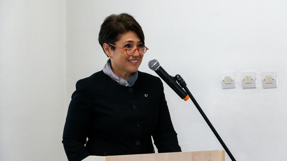 a woman is delivering her speech on the stage. 