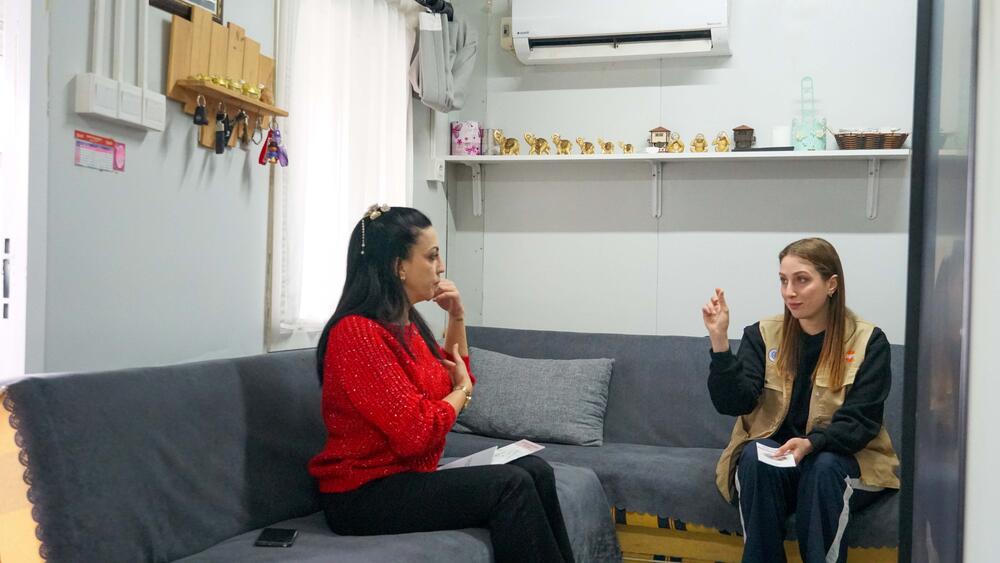 Two women talking to each other in a container.