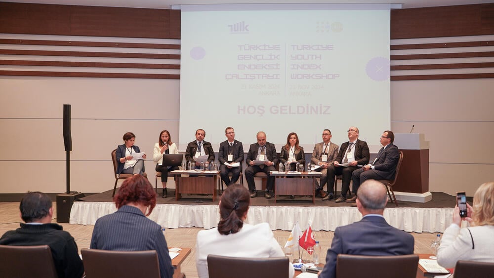 Panelists are seen seated in the stage.