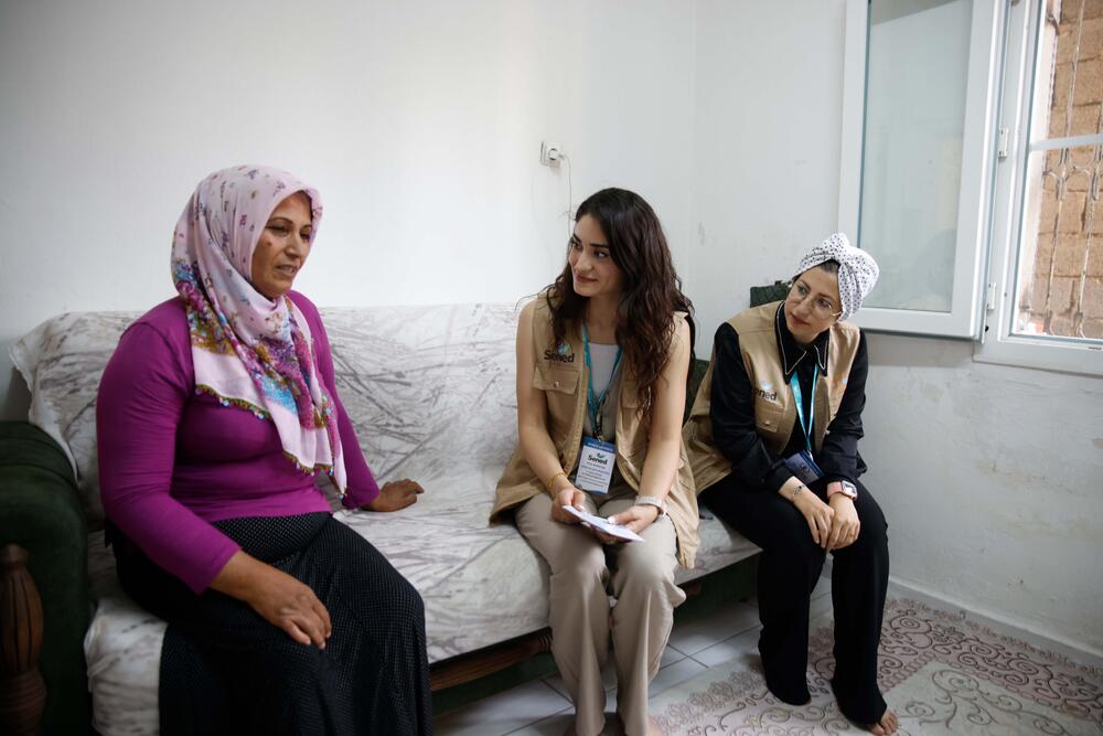 SENED’s personnel, UNFPA’s partner on site, are with ​​Saime, informing her of the services of UNFPA and SENED. ©UNFPA Türkiye