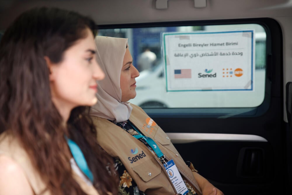 SENED personnel in the car with the PRM logo visible on the window.