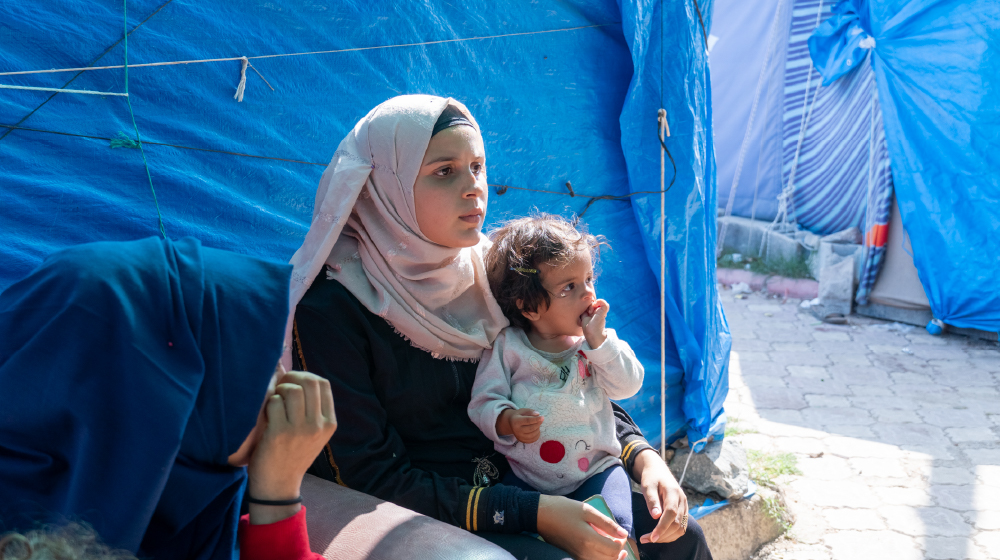 Esra, Antakya'daki bir geçici çadır yerleşiminde HASUDER'in verdiği eğitimi dinliyor, © Eren Korkmaz / UNFPA Türkiye