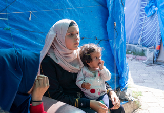 Esra, Antakya'daki bir geçici çadır yerleşiminde HASUDER'in verdiği eğitimi dinliyor, © Eren Korkmaz / UNFPA Türkiye