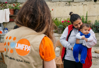 UNFPA personnel with an earthquake survivor mother. © UNFPA Türkiye/Eren Korkmaz