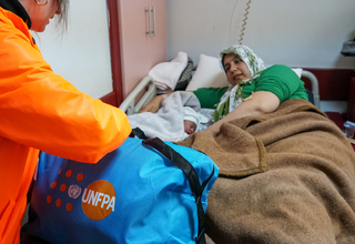 Hatice and her newborn baby, Kumsal laying down in a hospital bed.