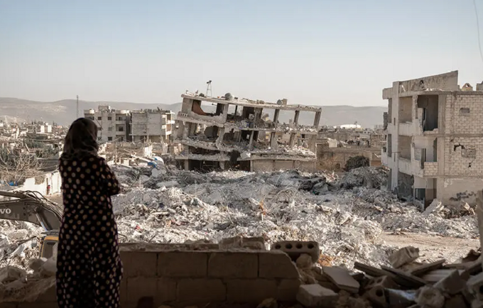 A woman looks over a scene of destruction in Jinderis, Syria. © UNFPA/Karam Al-Masri