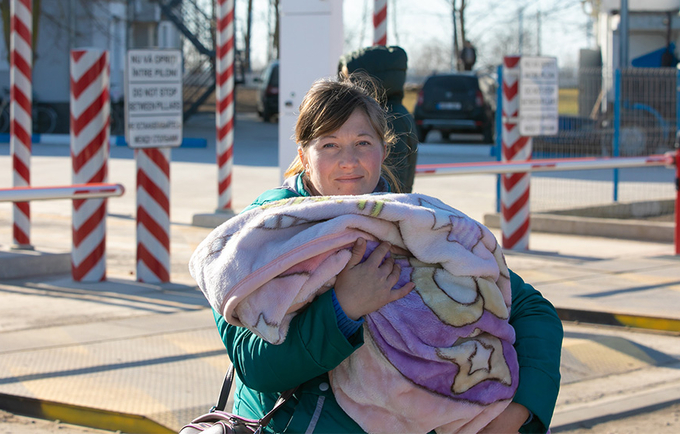 Bir bebek tutan bir mülteci kadın.