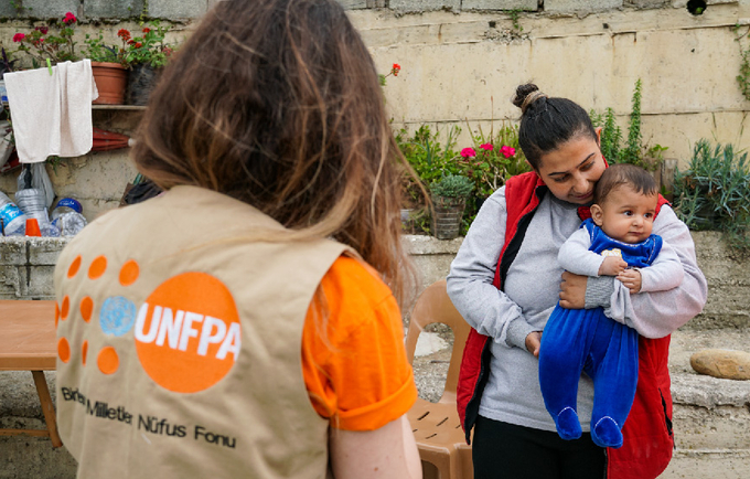 UNFPA personeli depremden etkilenen bir anne ve bebeğiyle. © UNFPA Türkiye/Eren Korkmaz