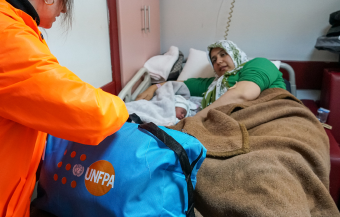 Hatice and her newborn baby, Kumsal laying down in a hospital bed.