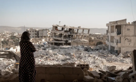 Bir kadın Suriye’nin Jinderis kentindeki yıkımı izliyor. © UNFPA/Karam Al-Masri
