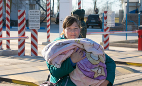 A refugee woman holding an infant.