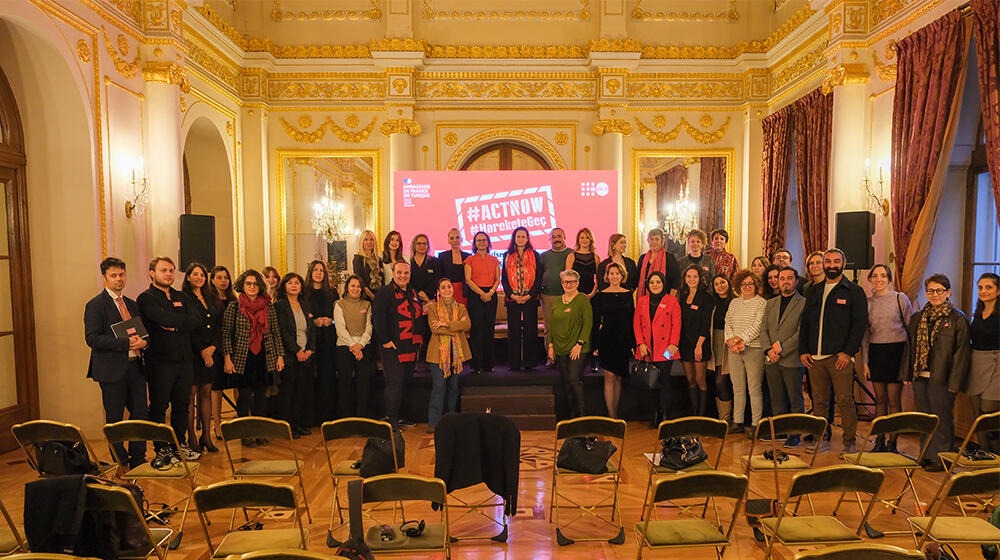 Attendees of the event gathered together at the end of the event in the stage.