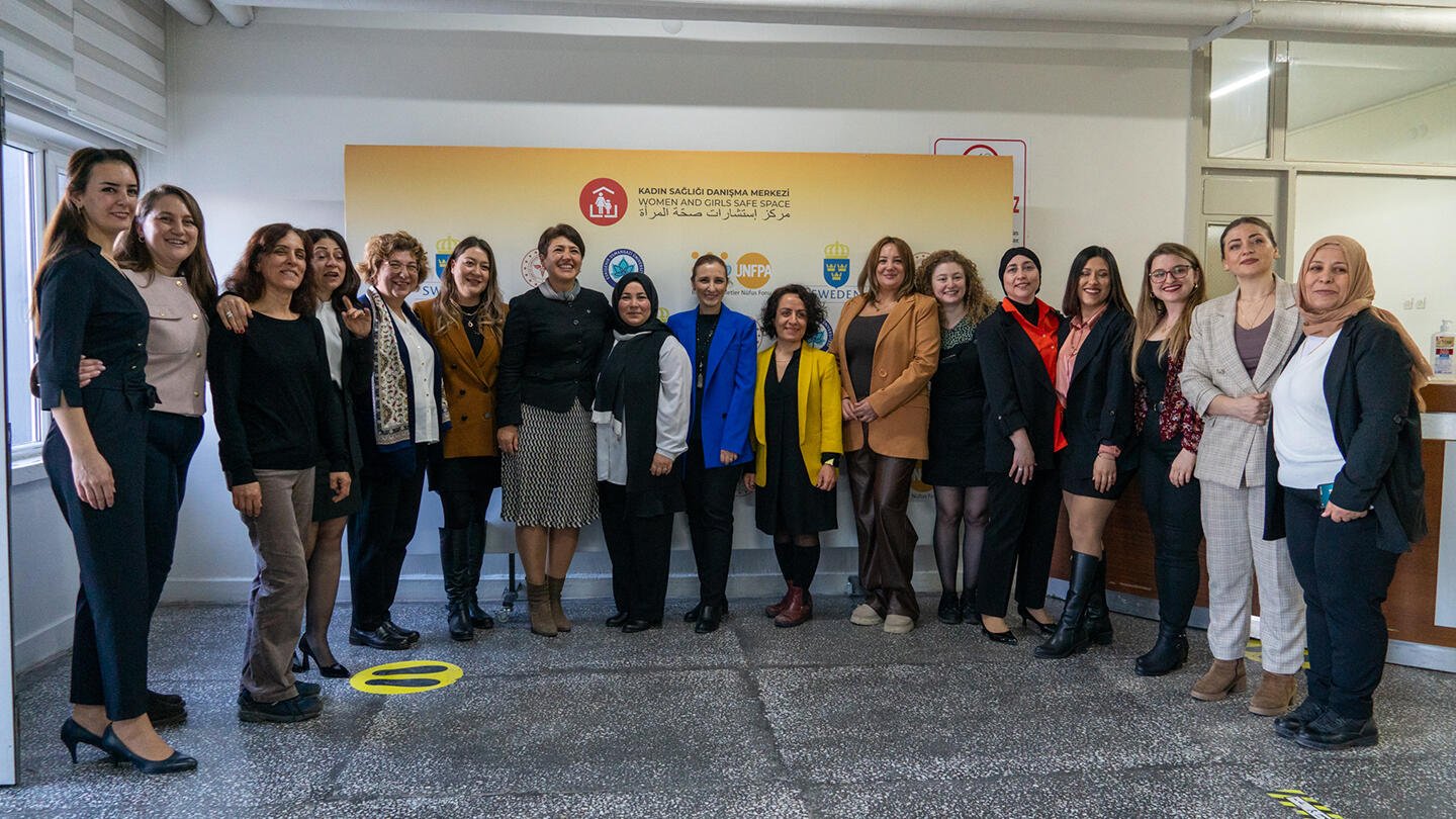  Alt- women who attended the event gathered together for a family photo and are smiling.