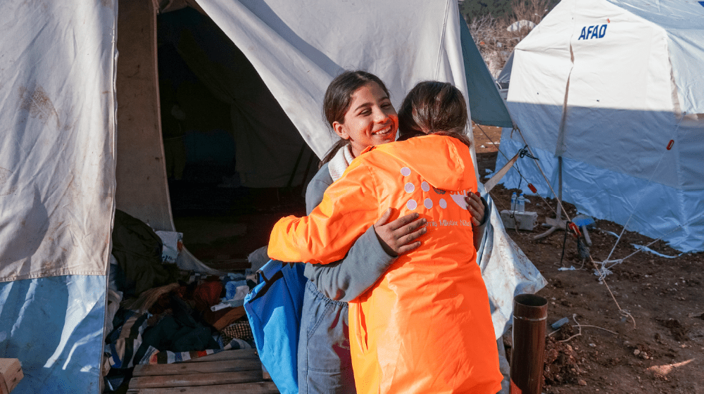 UNFPA personnel at the tent settlement with a survivor 