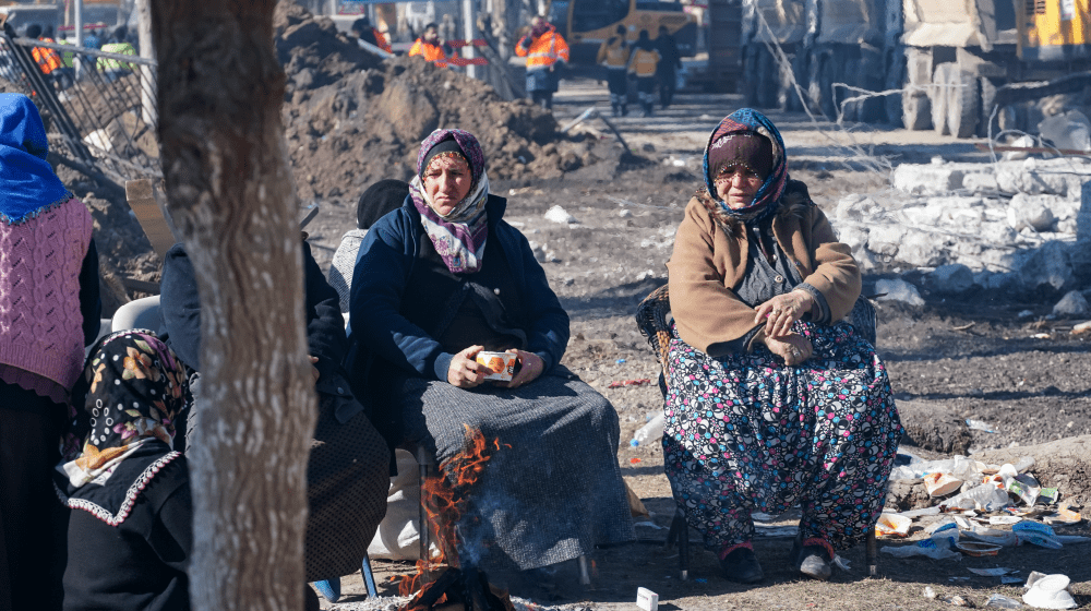 Adıyaman’da sevdiklerinden haber almak için enkazı izleyen kadınlar. © Eren Korkmaz / UNFPA Türkiye