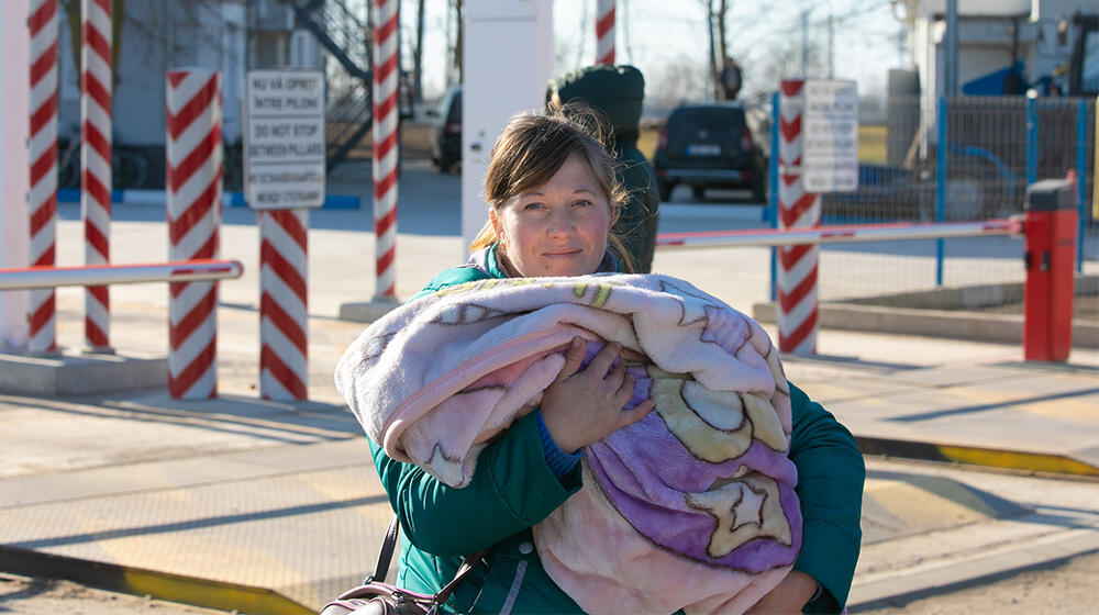 A refugee woman holding an infant.