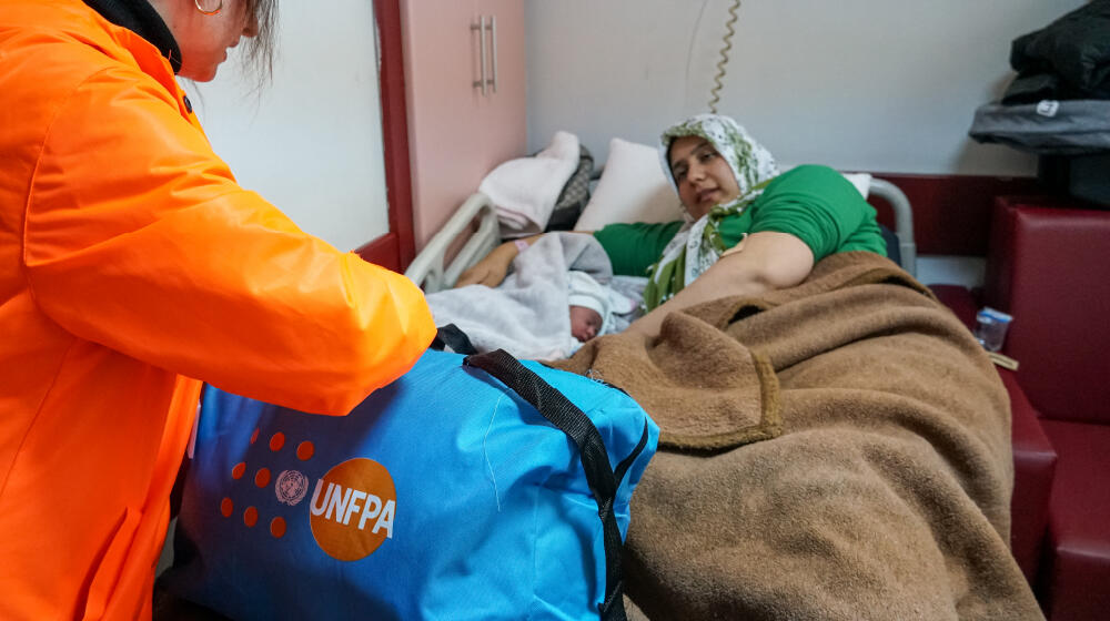 Hatice and her newborn baby, Kumsal laying down in a hospital bed.