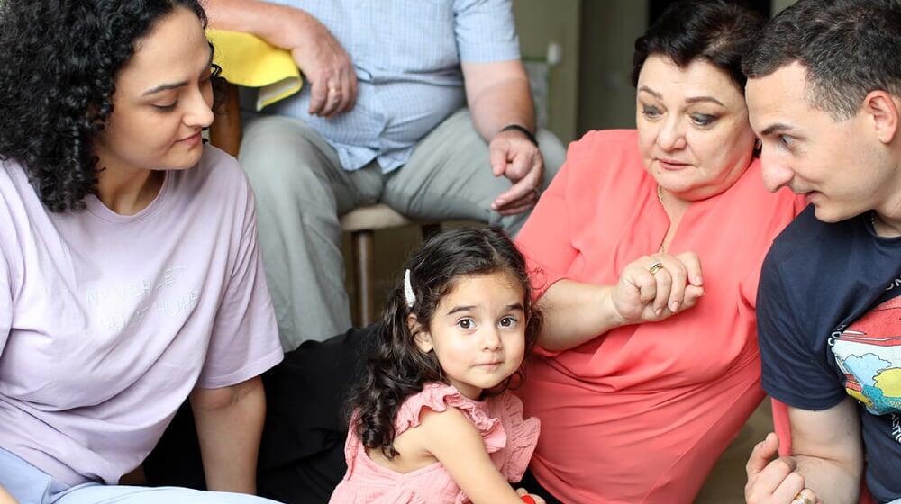 a group of people sits together looking at the children in the middle